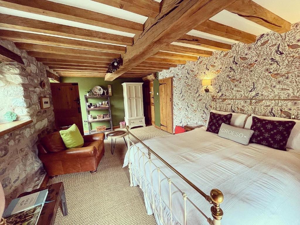 - une chambre avec un grand lit dans un mur en pierre dans l'établissement The Cowshed, à Llangollen