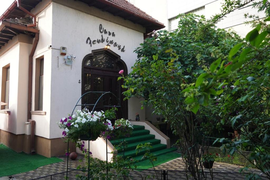 a house with a front door with stairs and flowers at Casa Ferdinand in Constanţa
