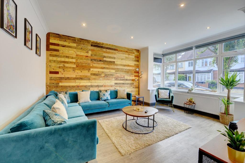 un soggiorno con divano blu e tavolo di The Cedars Luxury accommodation Fantastic location 15 minutes from Gatwick 13 minutes to London bridge a South Norwood