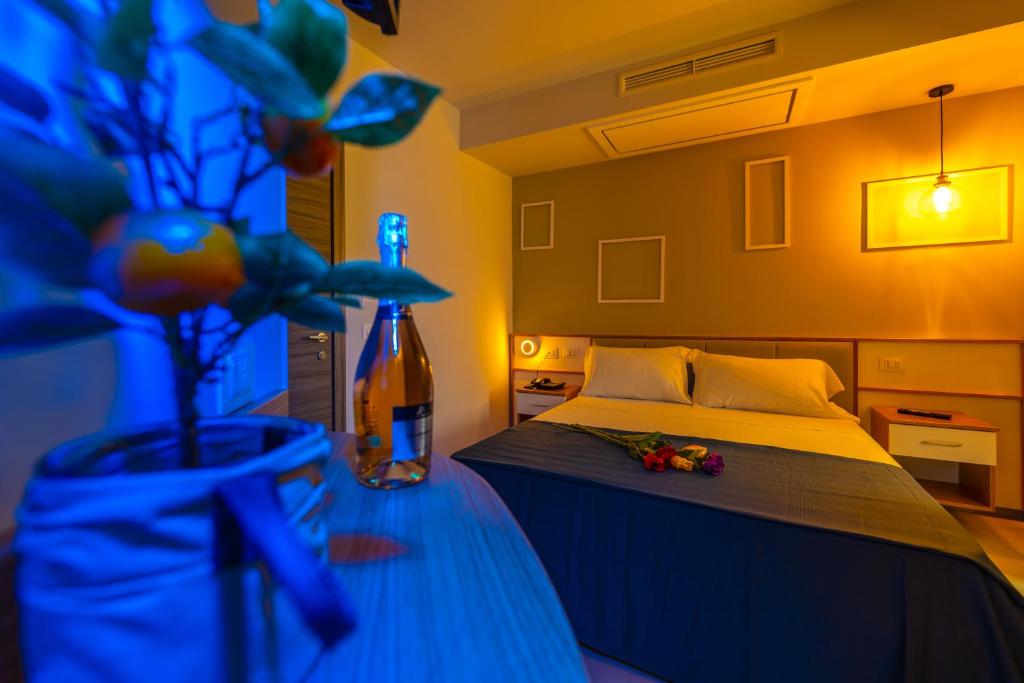 a bedroom with a bed and a vase with flowers at ELISEO PALACE TROPEA in Tropea