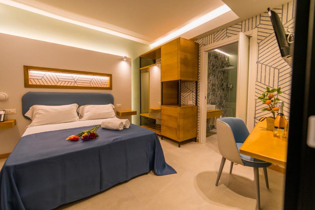 a bedroom with a bed and a table and a desk at ELISEO PALACE TROPEA in Tropea