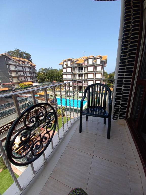 een balkon met een bank en een zwembad bij Apartamento Noja Beach in Noja