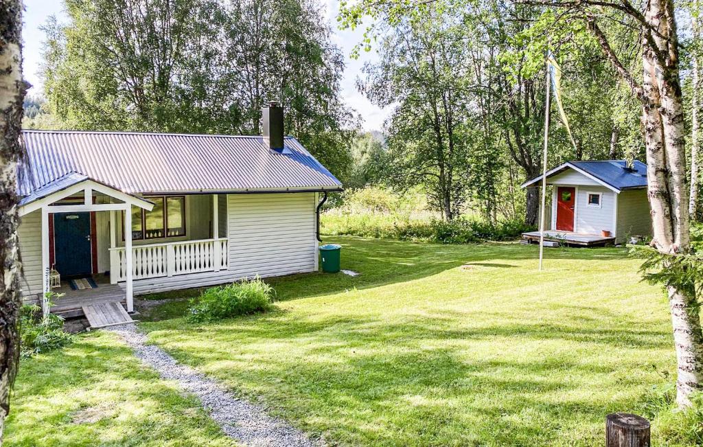 a small house in a yard with a yard at Awesome Home In Brcke With Lake View in Baksjöbodarna