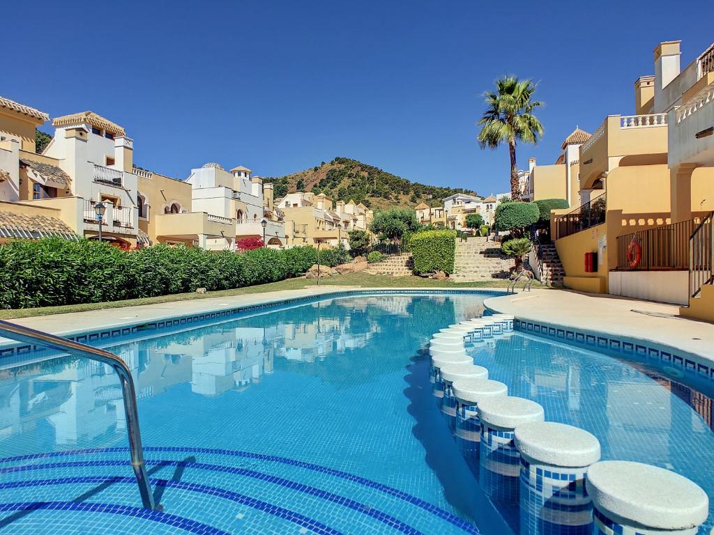 a swimming pool with stools in front of some buildings at La Manga Club - Las Atalayas 7709 in Atamaría