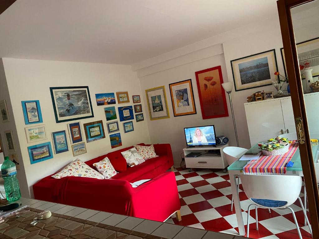 salon z czerwoną kanapą i stołem w obiekcie ARGENTARIO… tutto da scoprire w mieście Porto Santo Stefano