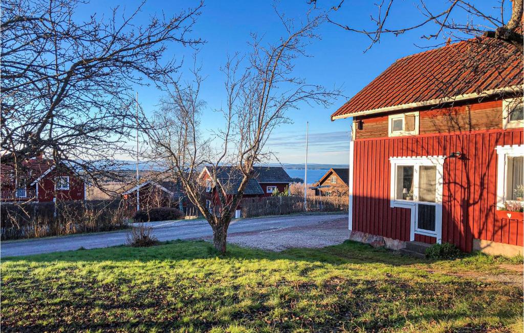 une maison rouge avec un arbre devant elle dans l'établissement Cozy Home In Rttvik With Kitchen, à Rättvik