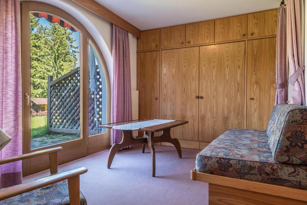 Pokój z łóżkiem, stołem i oknem w obiekcie Ferienparadies Sabina Schlern w mieście Alpe di Siusi