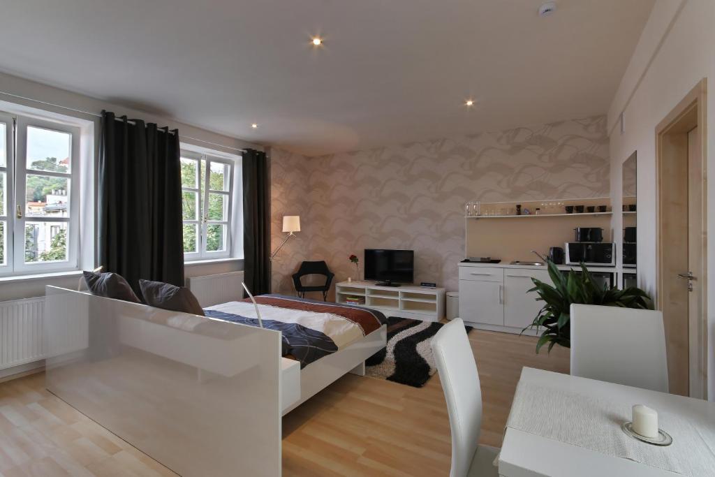 a living room with a bed and a table and chairs at Atrium Apartments in Brno