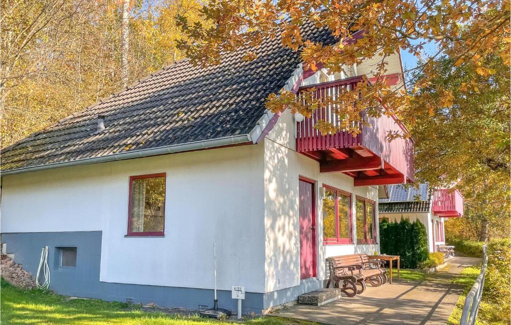 Dieses weiße Haus verfügt über eine Veranda und einen Balkon. in der Unterkunft Ferienhaus 12 In Kirchheim in Reimboldshausen
