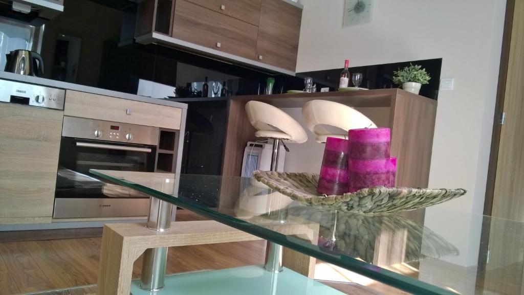 a glass table in a kitchen with purple candles on it at Apartment Pertu in Budapest