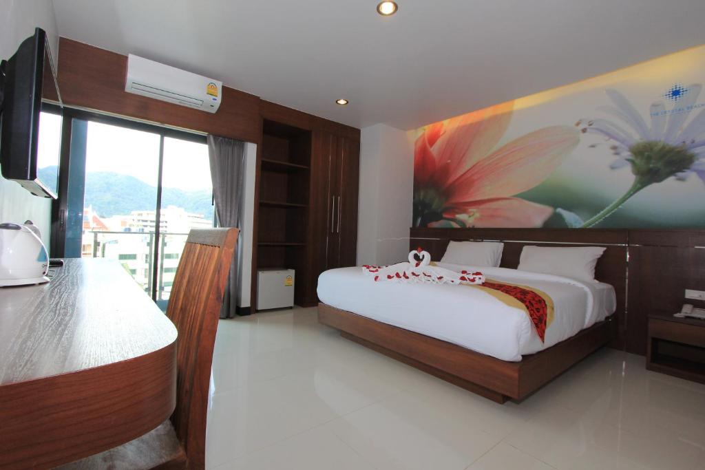 
a hotel room with a large bed and a large window at The Crystal Beach Hotel in Patong Beach
