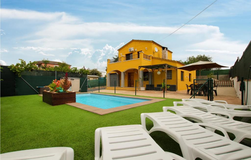 Casa amarilla con piscina y sillas de césped blancas en Amazing Home In Sils With Wifi, en Sils