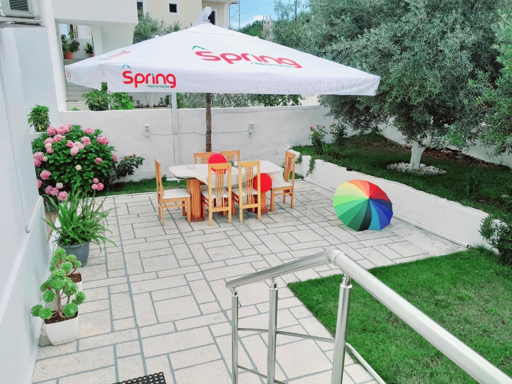 a patio with a table and chairs and an umbrella at GB Rooms in Ksamil