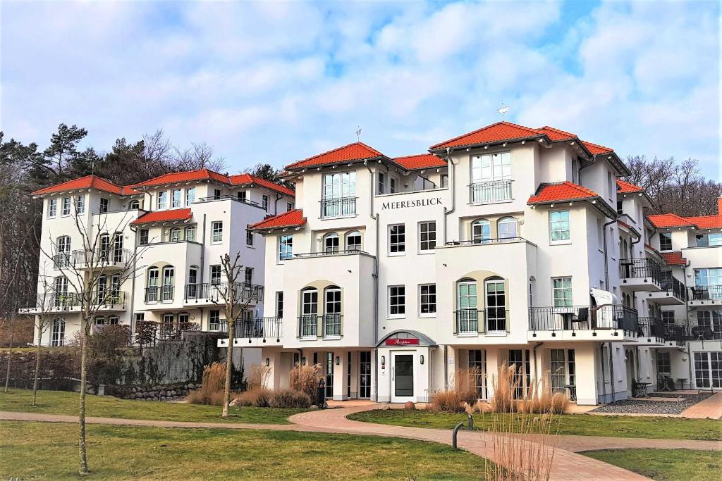 a large white building with red roofs at Haus Meeresblick - Ferienwohnung Strandlaeufer (Ref. 128683) in Baabe