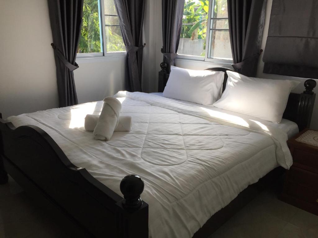 a bedroom with a bed with white sheets and pillows at Mew House suanmali lamai in Koh Samui 