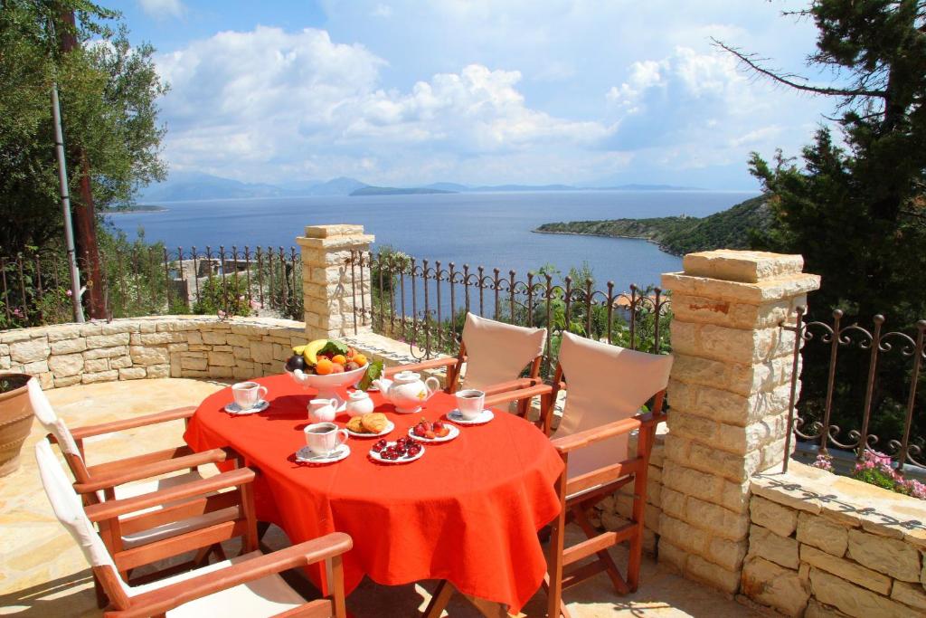 una mesa con un mantel rojo en un patio con vistas en Villa Votsalo en Kiónion