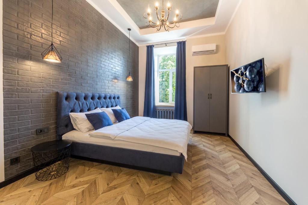 een slaapkamer met een bed en een bakstenen muur bij Central Apartments Maidan Area in Kiev