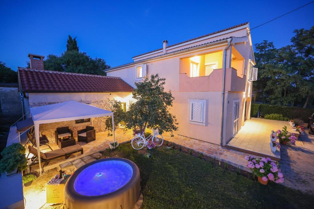 a house with a swimming pool in the yard at Apartman Berto in Vrsi