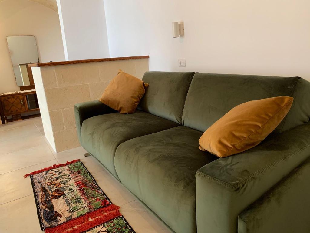 a green couch with two pillows on it in a living room at La Tortorella in Ginosa
