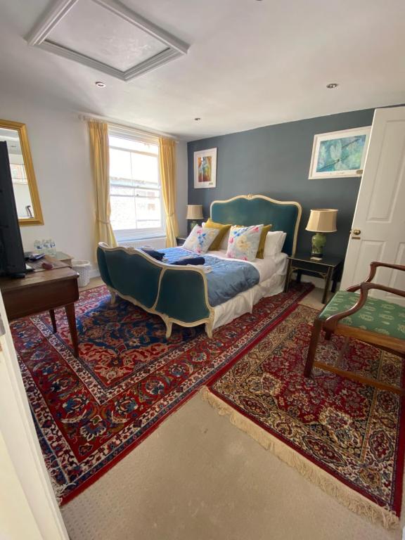 1 dormitorio con 1 cama, 1 silla y 1 alfombra en 28 King Street en Margate