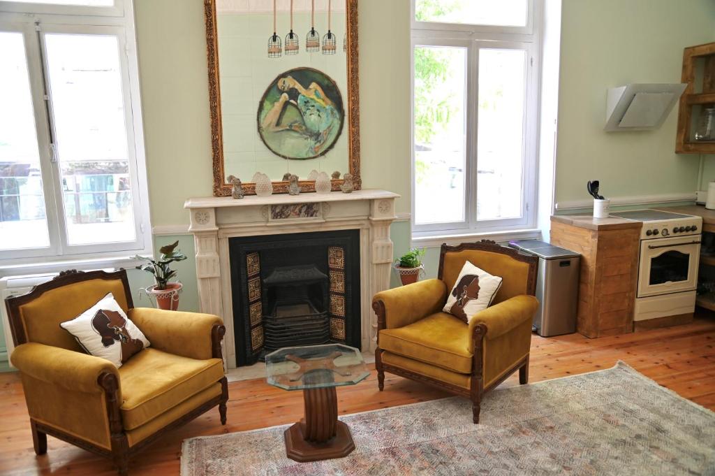 a living room with two chairs and a fireplace at Baloo Hostel in Athens