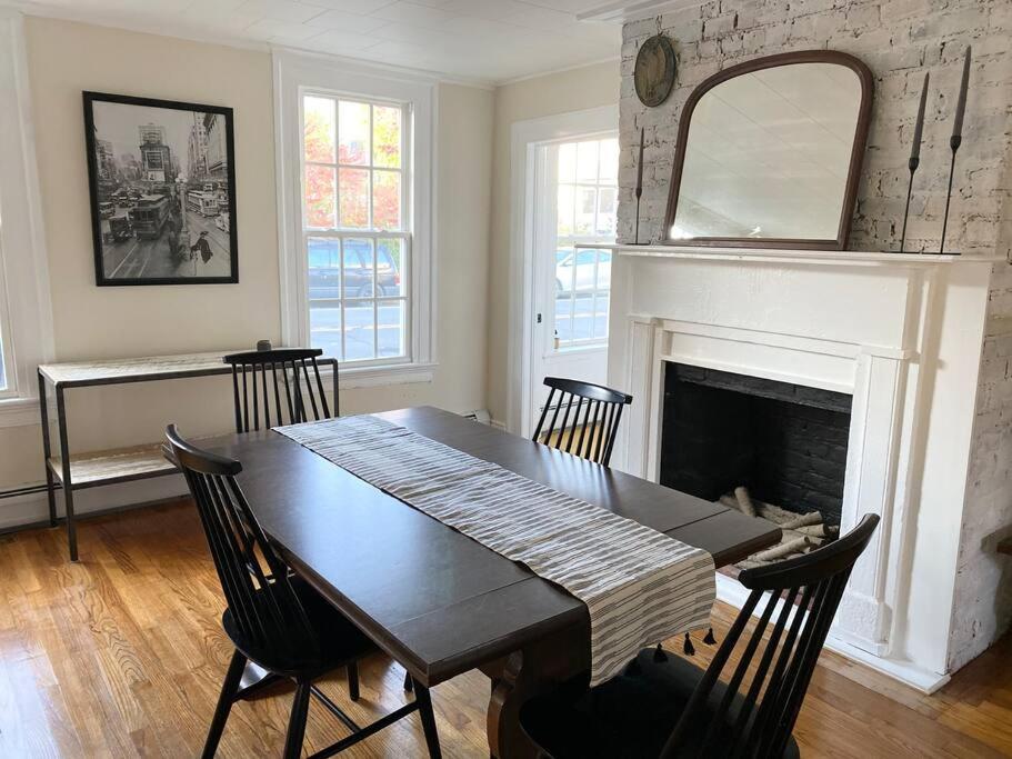ein Esszimmer mit einem Tisch und einem Kamin in der Unterkunft The Colonial on the Hudson in Athens