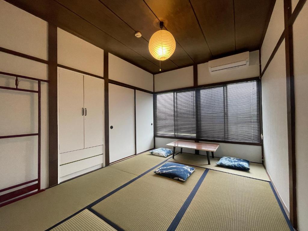 an empty room with a table and some windows at Guesthouse tabi-tabi - walk to Ohama Beach - Max 12 ppl in Shimoda