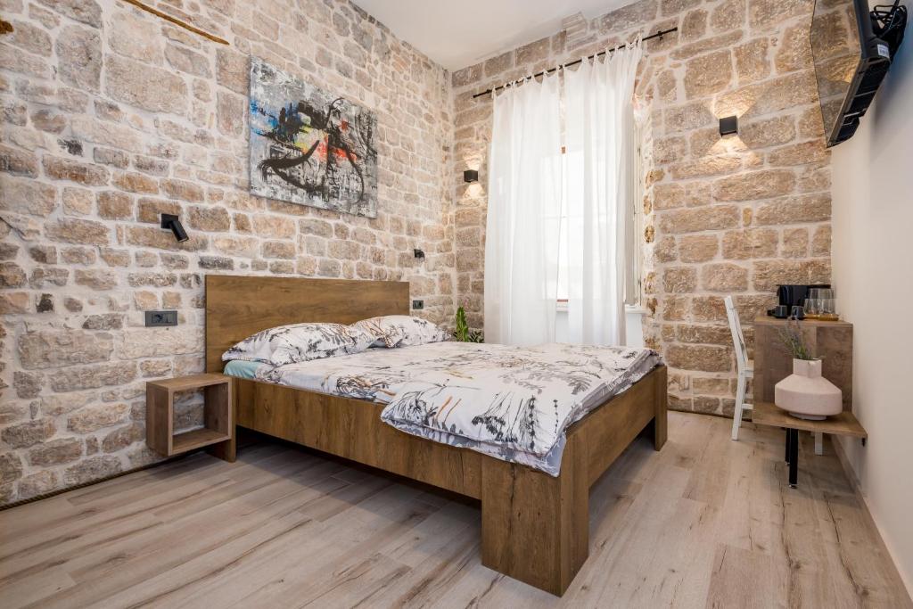 sypialnia z ceglaną ścianą z łóżkiem w obiekcie House Poletti w Szybeniku