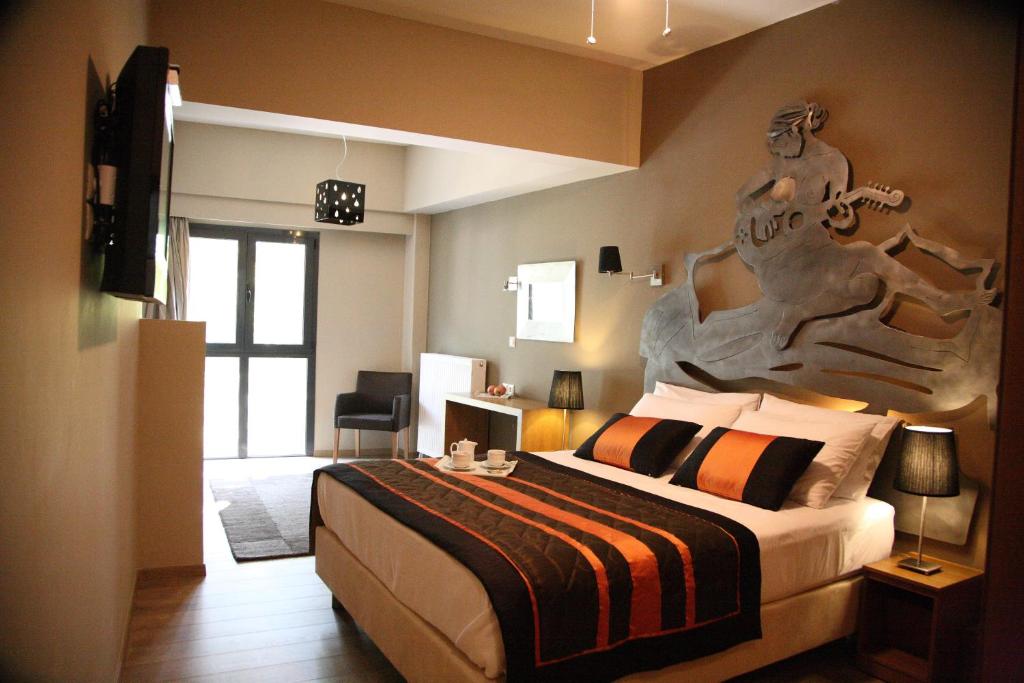 a bedroom with a large bed with a sculpture on the wall at Mousiko Pandoxeio in Stení Dhírfios