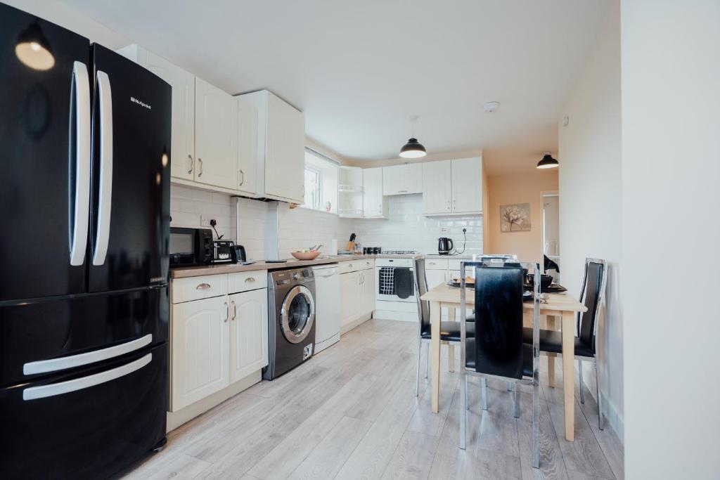 uma cozinha com um frigorífico preto e uma mesa em Bellengers Apartments em Kidlington