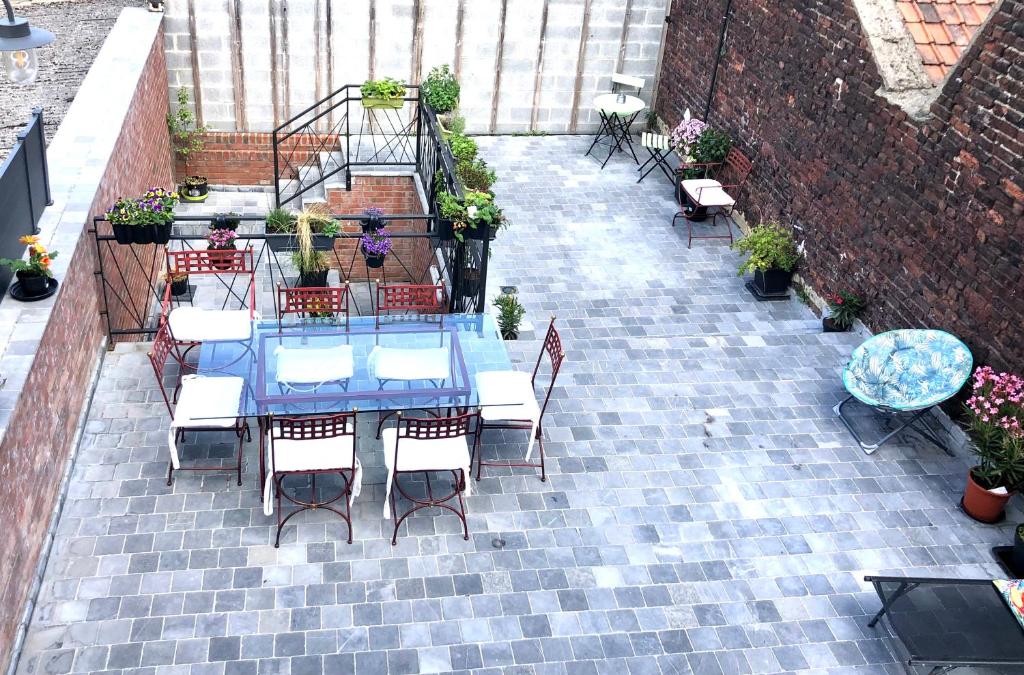 eine Terrasse mit einem blauen Tisch, Stühlen und Pflanzen in der Unterkunft Loft atypique 192m2, terrasse, aux portes de Lille in Roubaix