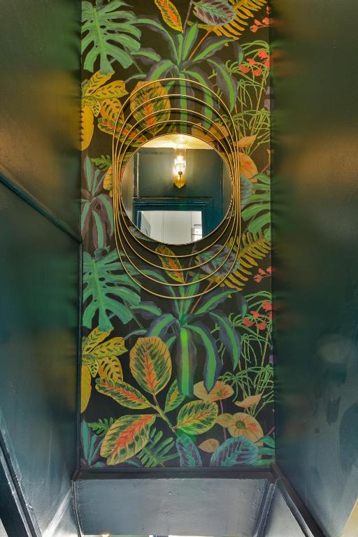 a hallway with a wall with a mural of plants at indépendant flat: canal st martin&amp;trains stations! in Paris