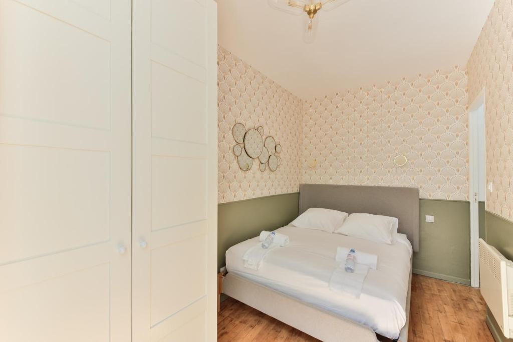 a bedroom with a white bed and two rings on the wall at indépendant flat: canal st martin&amp;trains stations! in Paris