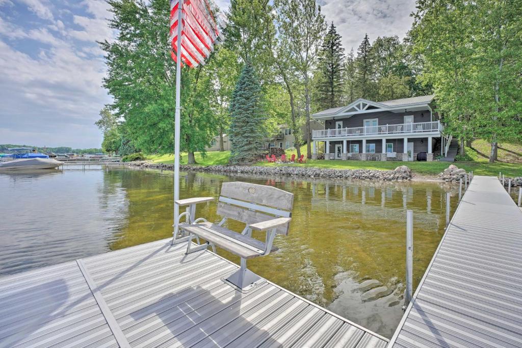 a bench sitting on a dock with a flag at Coldwater Family Retreat with Boat Dock and Grill! in Coldwater