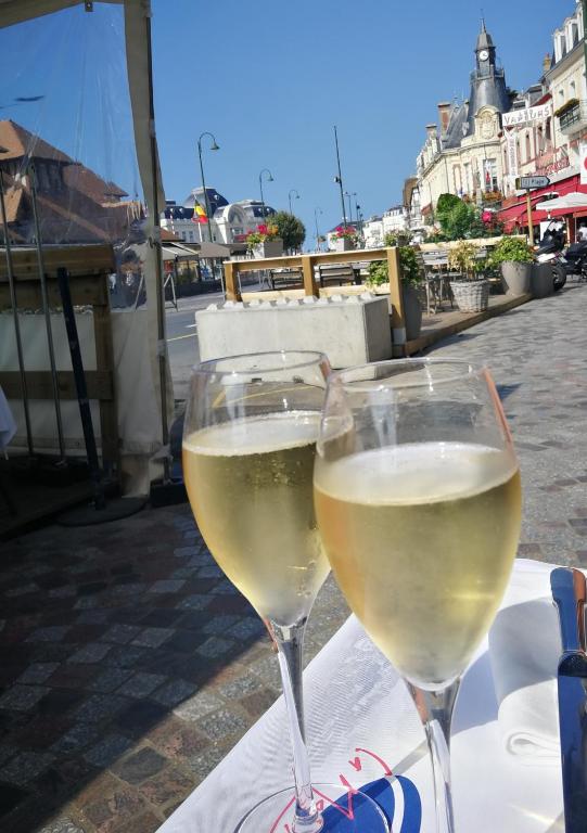 two glasses of white wine sitting on a table at Study du pêcheur in Trouville-sur-Mer