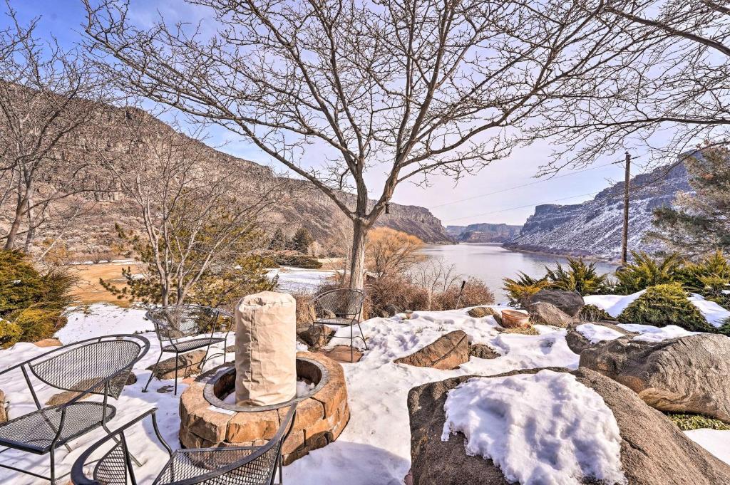 un patio nevado con sillas y una chimenea con vistas al río en Vivid Twin Falls Retreat with Snake River Views en Twin Falls