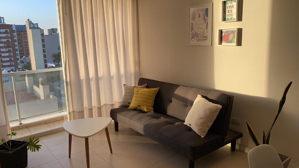 Departamento céntrico - Leer condiciones y precio في ريو كوارتو: غرفة معيشة مع أريكة ونافذة