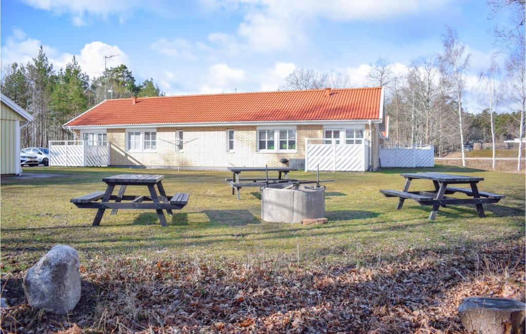 a group of picnic tables in front of a house at Awesome Apartment In Pskallavik With Wifi And 1 Bedrooms in Påskallavik