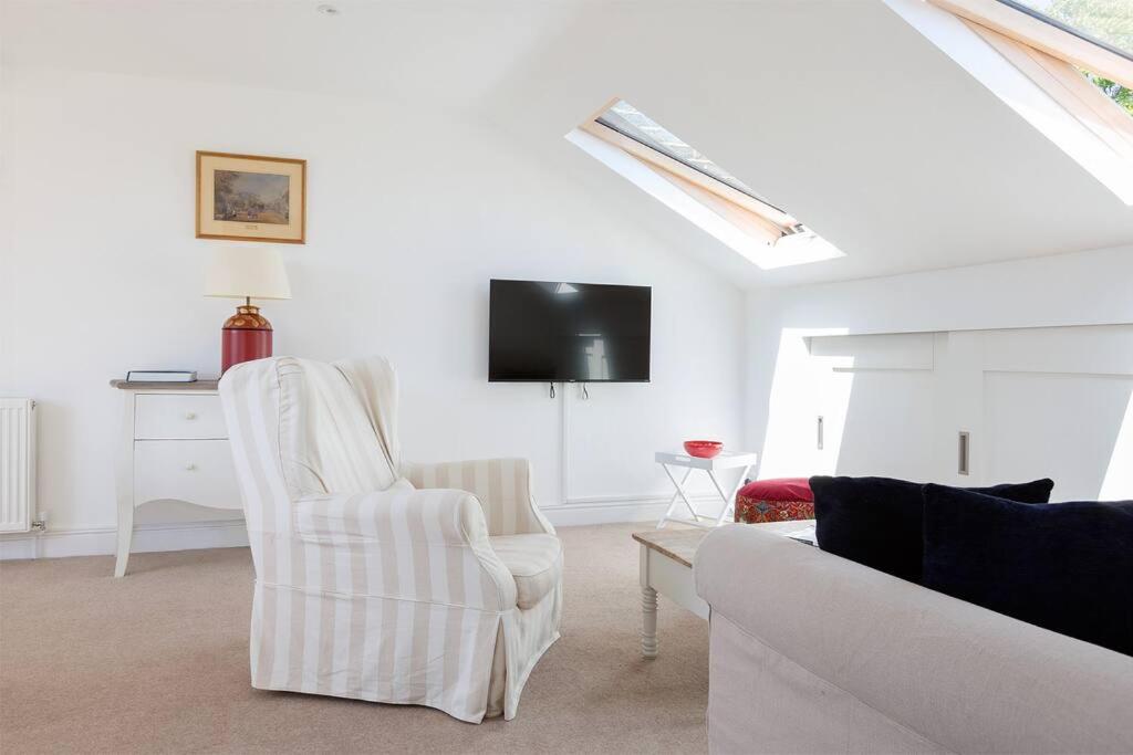 a white living room with a couch and a tv at Spacious 3 bedroom flat with terrace in London