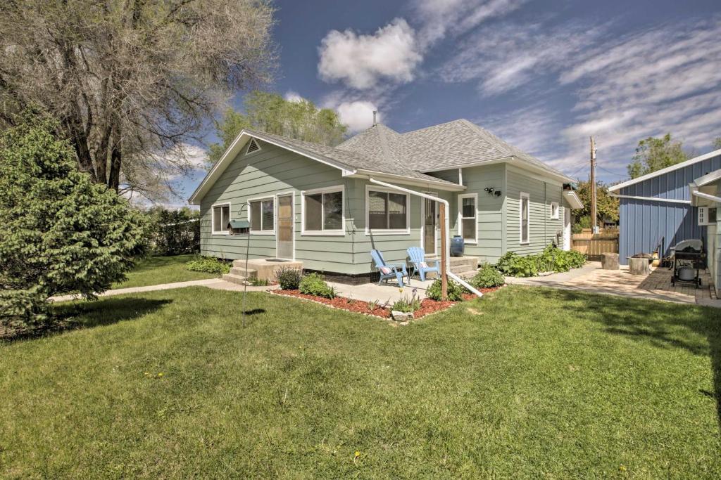 uma pequena casa com um relvado em frente em Walkable Ten Sleep House with Patio and Sunroom! em Ten Sleep