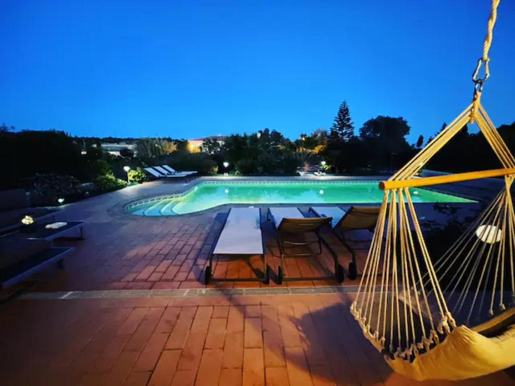 a hammock in front of a pool at night at Villa Rubix in Luz
