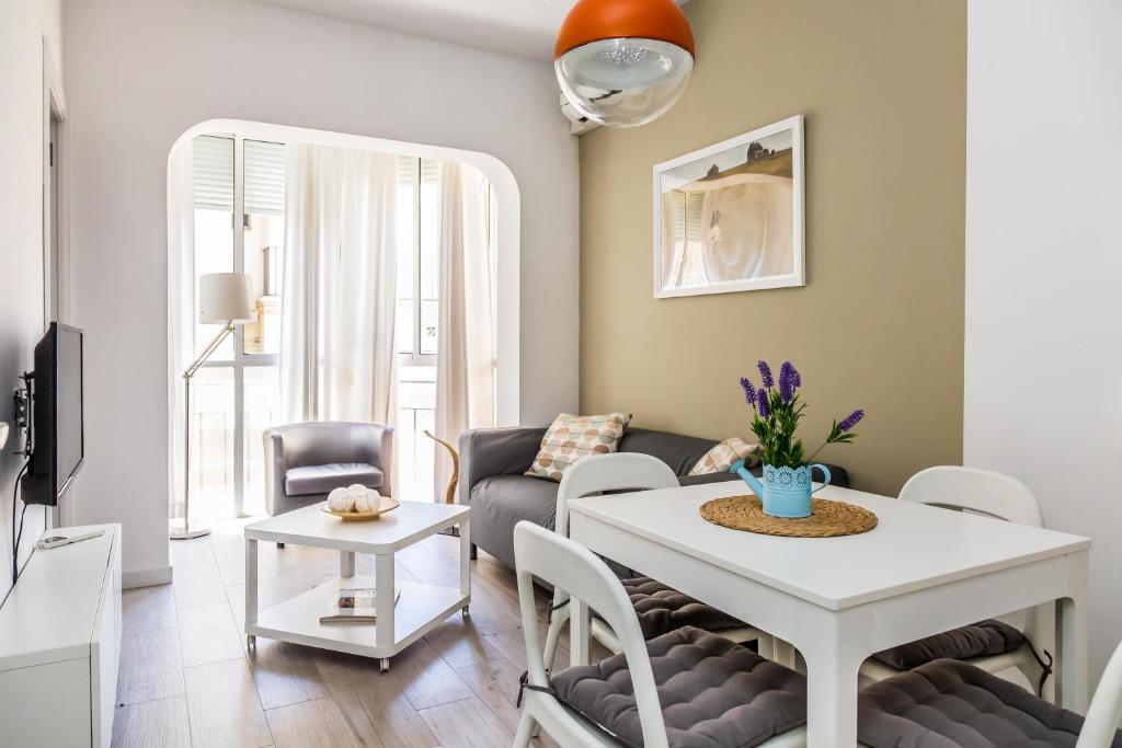 een woonkamer met een tafel en een bank bij Opening Doors Gràcia in Barcelona