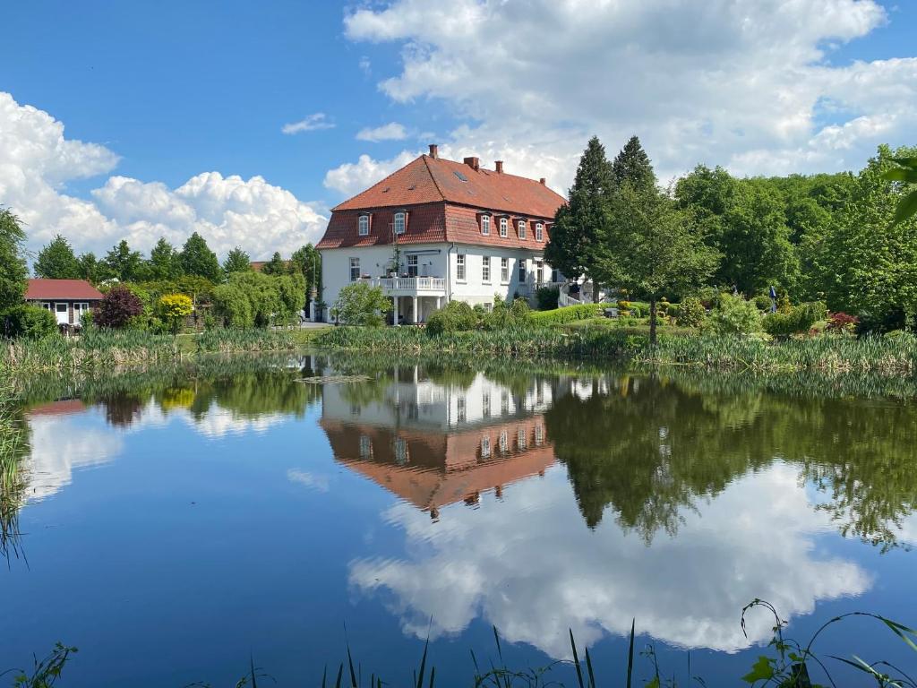 una casa se refleja en el agua de un lago en Jagdschloss lalendorf en Lalendorf