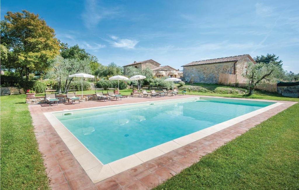 a swimming pool in a yard with chairs and umbrellas at Casa Roseto in San Donato in Poggio
