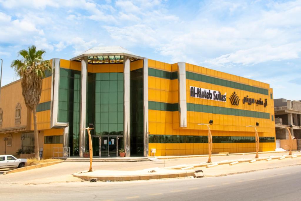a yellow building with a palm tree in front of it at ال متعب سويتس خريص in Riyadh