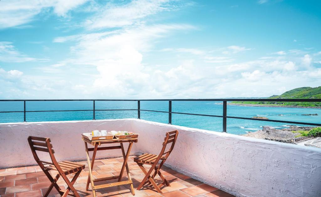 a table and chairs on a balcony overlooking the ocean at Bethlehem B&amp;B Kenting in Eluan