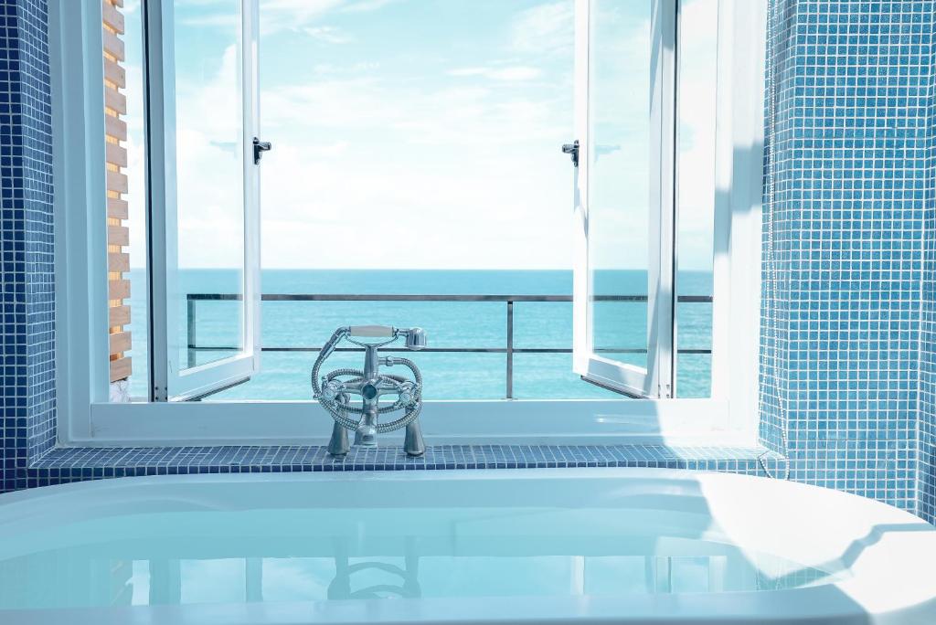 a bath tub in a bathroom with a view of the ocean at Bethlehem B&B Kenting in Eluan