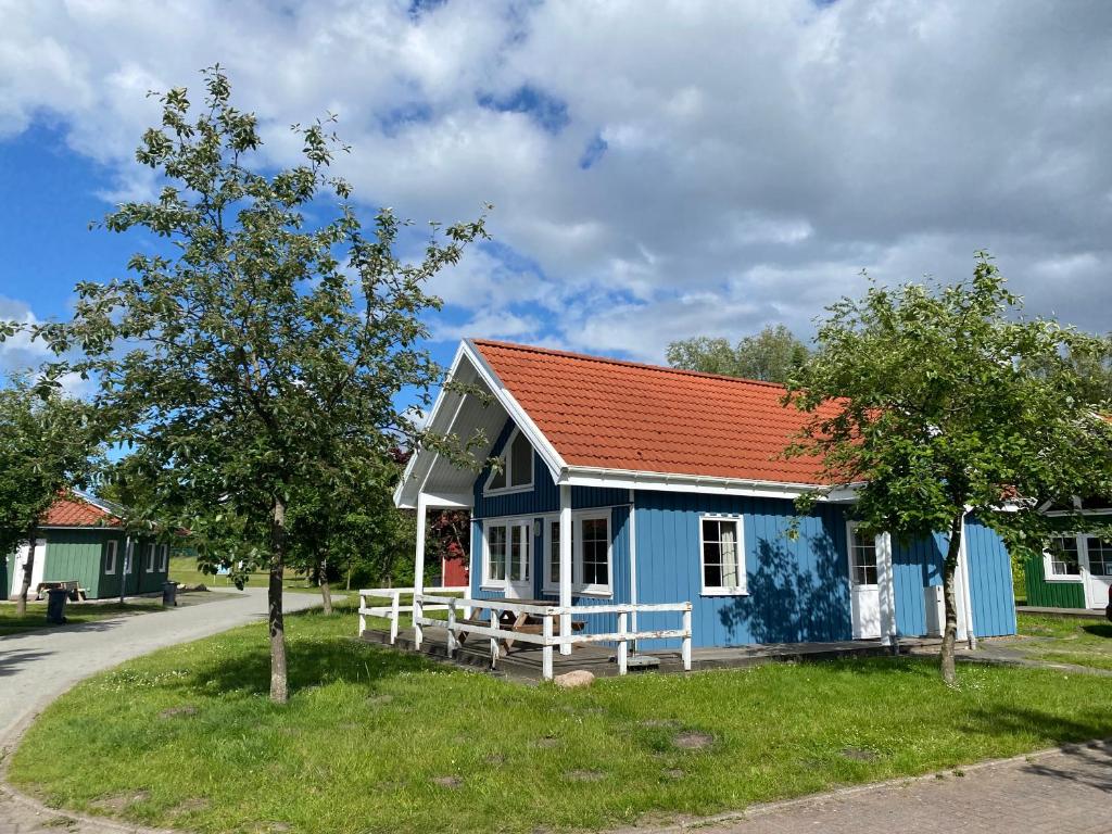 ein kleines blaues Haus mit orangefarbenem Dach in der Unterkunft THE KREIDESEE 47 - Hemmoor in Hemmoor