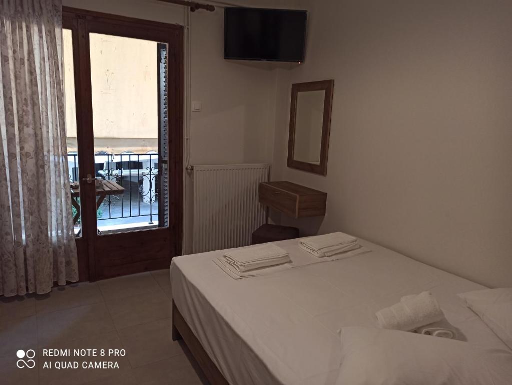 a small bedroom with a bed and a window at Eirini Filippou rooms in Kala Nera