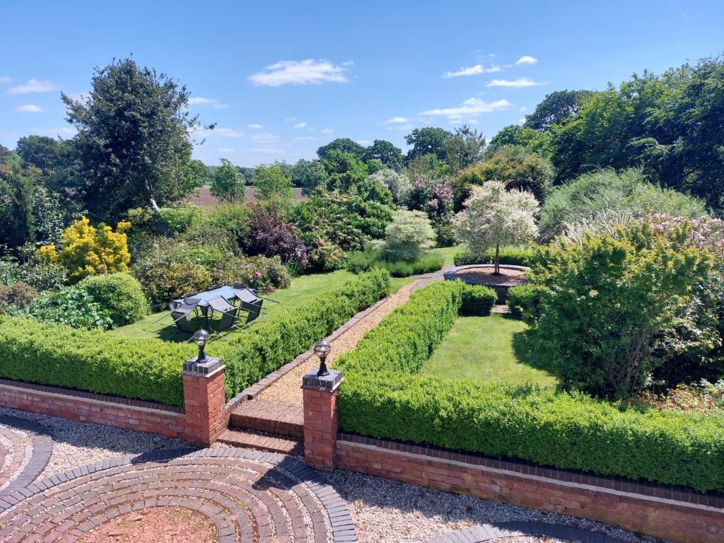 uma vista para um jardim com arbustos e árvores em Beautiful 3 Bedroom Cottage - Picturesque Retreat em Lichfield